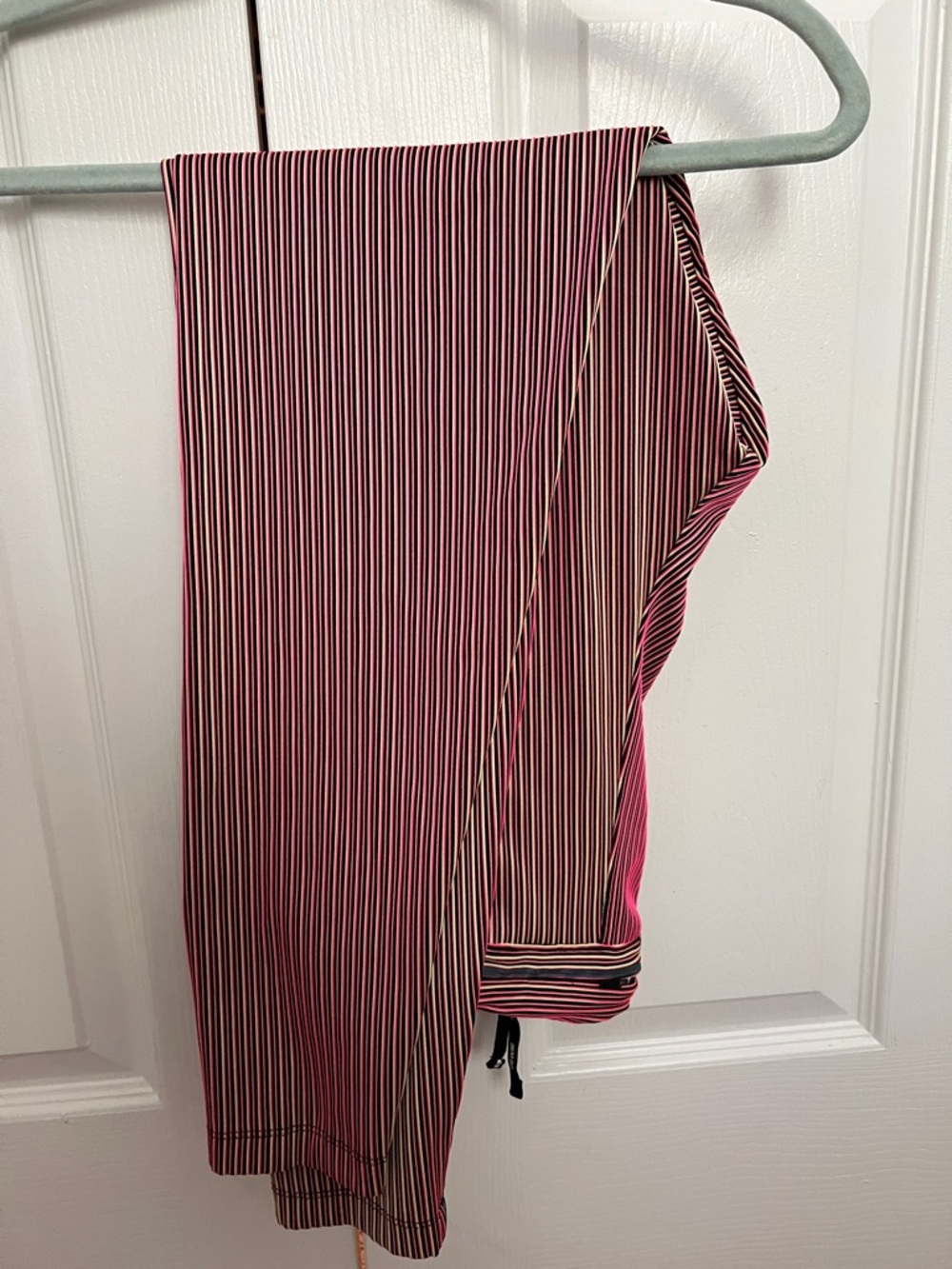 Nike Dri-fit pink black yellow striped running tights with pocket in rear.